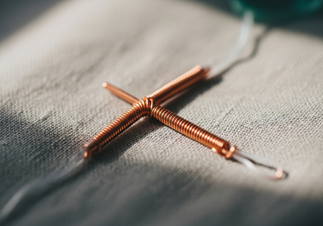 Vue macro d'un dispositif intra-utérin en cuivre posé sur un fond textile neutre